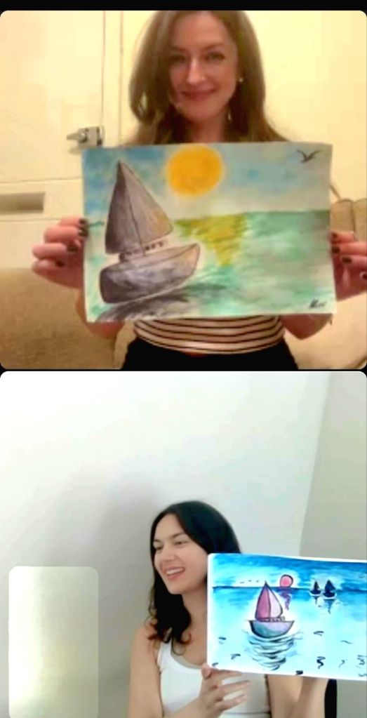 My students hold up their paintings of boats on the sea during an online art session.